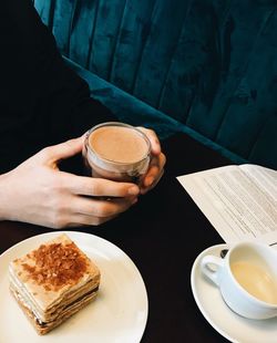 Cropped image of person holding cup of coffee