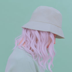 Rear view of woman wearing hat against white background