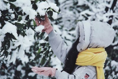 Woman wearing warm clothing while enjoying snowfall