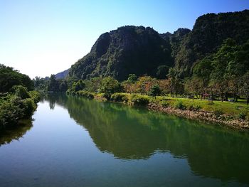 Scenic view of lake by mountains against clear sky