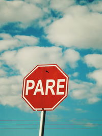 Low angle view of road sign against sky