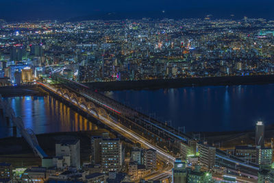 High angle view of illuminated bridge and buildings at night