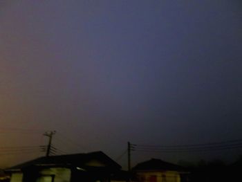 Low angle view of silhouette buildings against sky at night