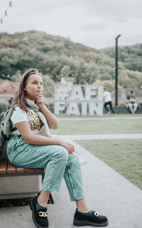 Portrait of young girl sitting on road