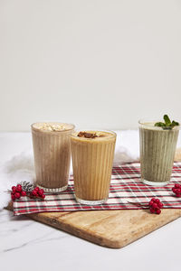 Three holiday smoothies on a white background with festive decor