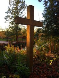 Cross on grass against sky