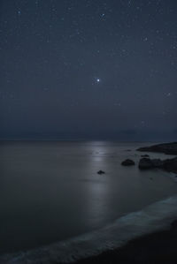 Scenic view of sea against clear sky at night