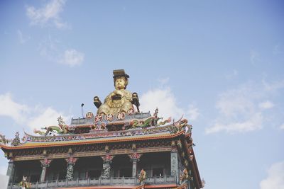 Low angle view of statue of temple against cloudy sky