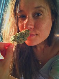 Close-up portrait of woman holding medical cannabis