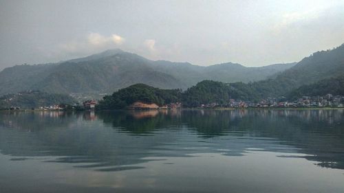 Scenic view of lake by mountains against sky