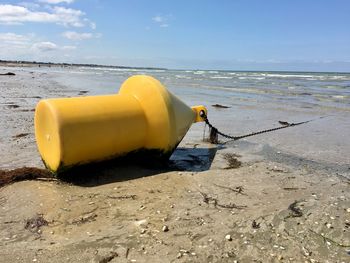 Scenic view of yellow buoy on beach 