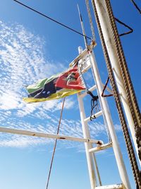 Low angle view of flags hanging on pole against sky