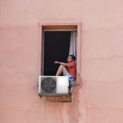 Rear view of woman standing against window