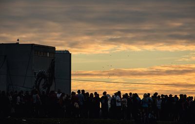 Silhouette of people in city at sunset