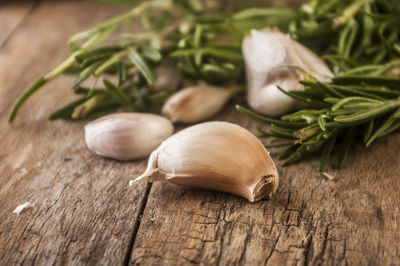 Close-up of garlic cloves and herbs on wooden table