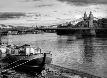 Bridge over river against cloudy sky