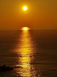 Scenic view of sea against orange sky