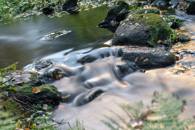 High angle view of stream flowing through rocks