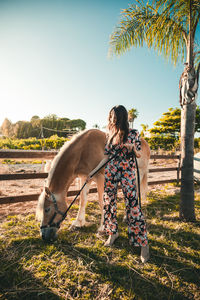 The girl relaxes with the white horse in the nature park