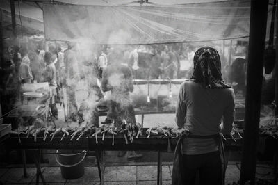 Rear view of woman selling street food