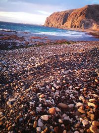 Stones on beach against sky