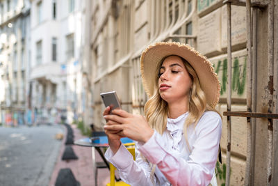 Young woman using mobile phone in city