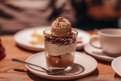 Delicious sweet chocolate ice cream in a transparent glass with chocolate chips and caramel cream