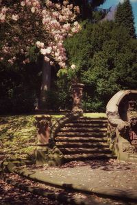 Statue by flowers against trees