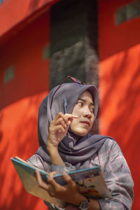 Portrait of young woman sitting on sofa at home