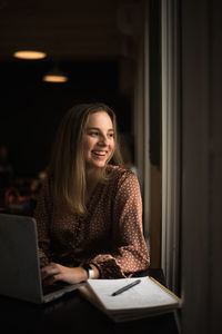 Young blogger influencer working in coffee shop by a window