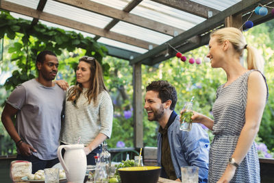 Multi-ethnic couple enjoying summer party on porch in log cabin