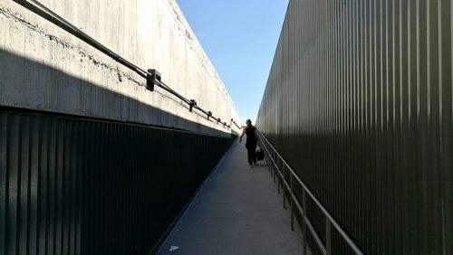 Rear view of man walking on road