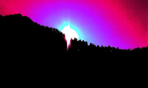 Silhouette of trees against sky at night