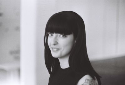 Portrait of smiling woman with bangs and long hair at home