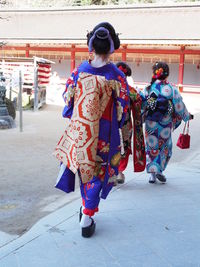 Rear view of women walking on street