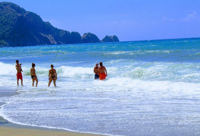 People on beach against clear sky