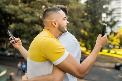 Side view of young man using mobile phone