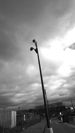 Street light against cloudy sky