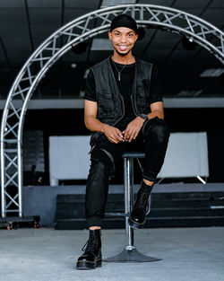 Portrait of young man smiling while sitting on staircase