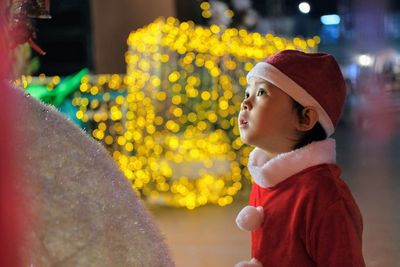 Children in red santa costumes are playing in the park sitting and thinking