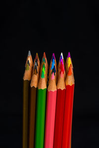 Close-up of colored pencils against black background