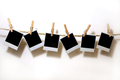 Close-up of clothespins hanging against white background