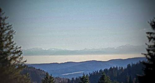 Scenic view of sea and mountains against sky