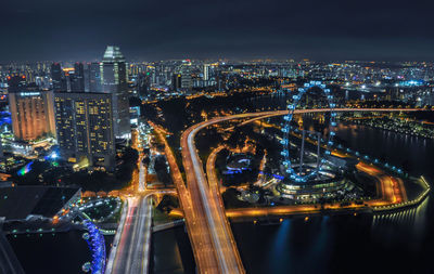High angle view of illuminated bridge and buildings against sky at night