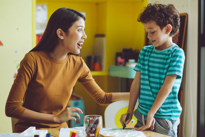 Mother and son standing on table