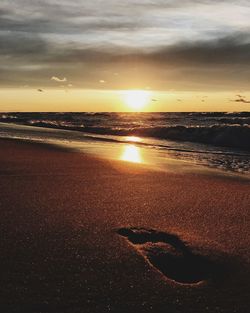 Scenic view of beach against sky during sunset