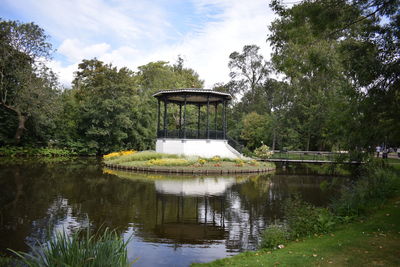 Gazebo by lake against sky