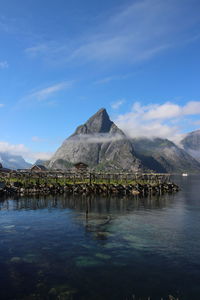 Scenic view of lake and mountains against blue sky