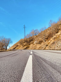 Road amidst field against sky