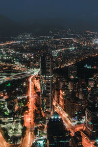 Aerial view of illuminated cityscape against sky at night